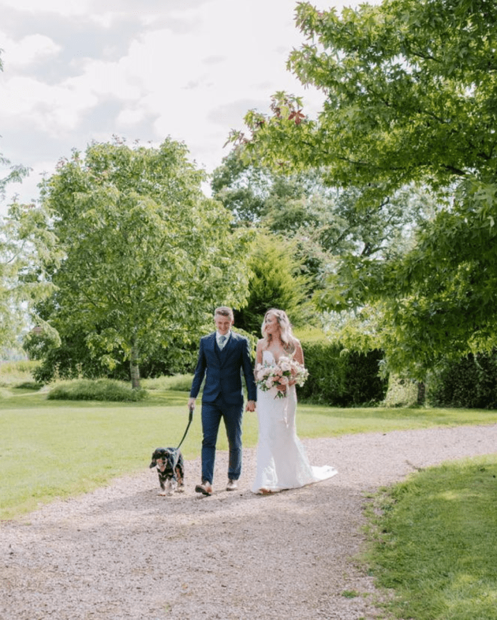 Bride and groom walking their outside at barn venue