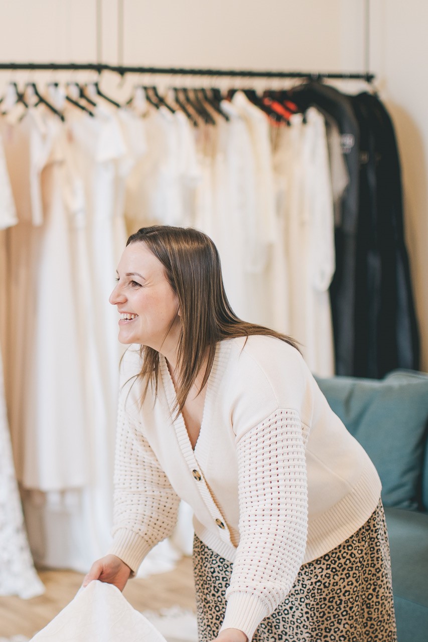 Woman smiling holding wedding dress