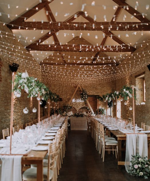 Wedding breakfast set up with rustic tables and lights