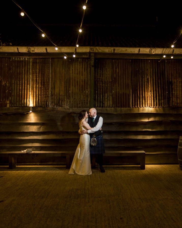 Bride and groom stood outside at barn wedding venue